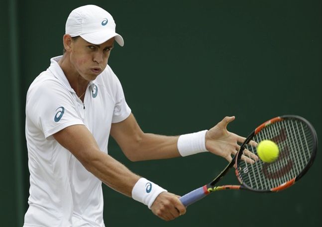 Vasek Pospisil of Canada returns a ball to Viktor Troicki of Serbia during their singles match at the All England Lawn Tennis Championships in Wimbledon London Monday