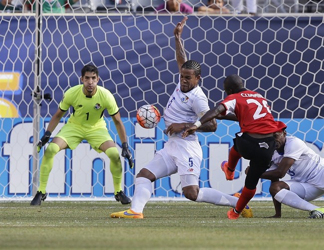 Panama's Roman Torres deflects a shot by Trinidad & Tobago's Keron Cummings as goalkeeper Jaime Penedo watches during the second half of a CONCACAF Gold Cup soccer match Sunday