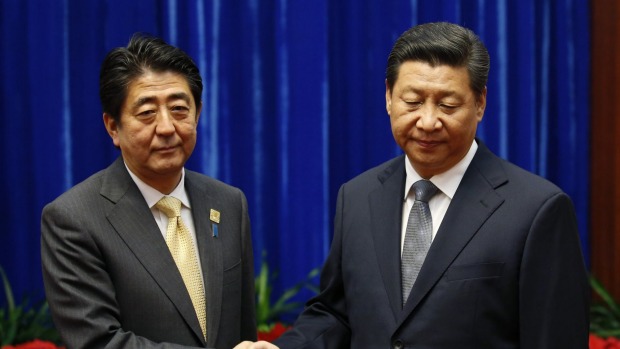 Japan's Prime Minister Shinzo Abe shakes hands with China's President Xi Jinping. Frosty relations between the two nations may pose an editorial problem the Financial Times's new owners Nikkei