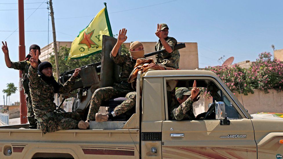 Kurdish Popular Protection Units fighters parade through the northern Syrian town of Tal Abyad