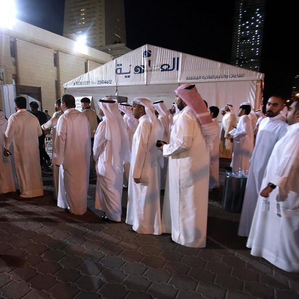 478840538-kuwaiti-mourners-queue-to-be-searched-by-security