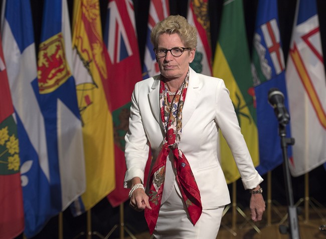 Ontario Premier Kathleen Wynne heads away from the microphone after talking with reporters at the summer meeting of Canada's premiers in St. John's on Thursday