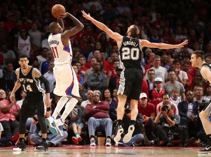 LOS ANGELES CA- APRIL 28 Jamal Crawford #11 of the Los Angeles Clippers shoots over Manu Ginobili #20 of the San Antonio Spurs during Game Five of the Western Conference quarterfinals of the 2015 NBA Playoffs at Staples Center