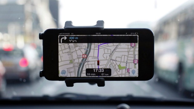 Waze is seen on a smartphone attached to the windscreen of a vehicle in Tel Aviv