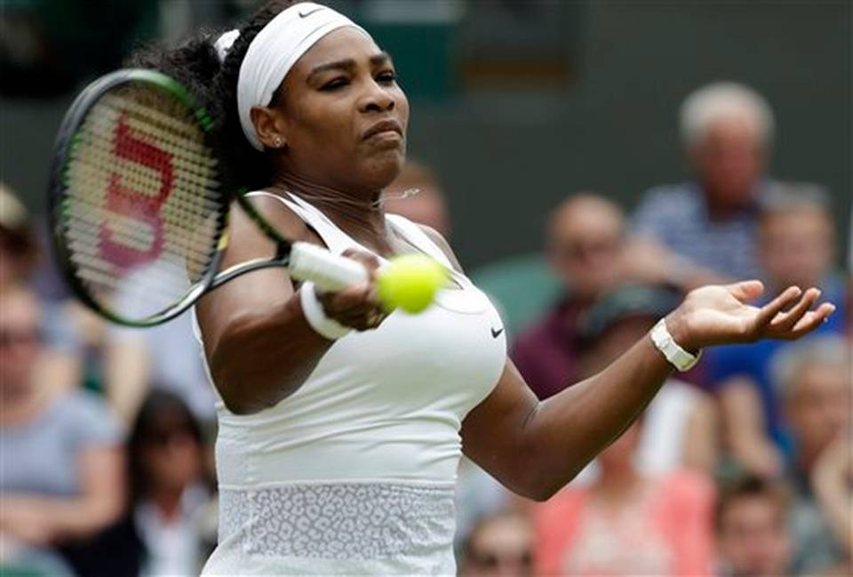 Serena Williams of the United States returns a ball to Venus Williams of the United States during their singles match at the All England Lawn Tennis Championships in Wimbledon London Monday