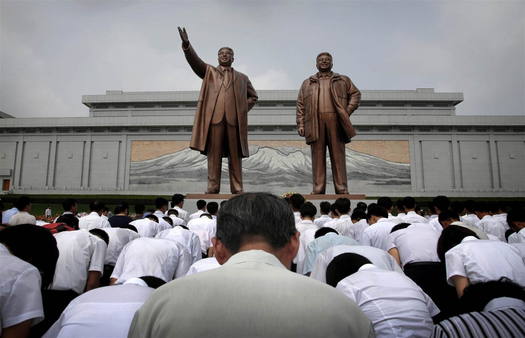 Image North Koreans bow in front of bronze statues of the late leaders Kim Il Sung and Kim Jong Il