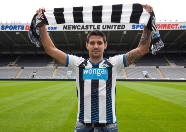 Aleksandar Mitrovic holds a Newcastle United shirt