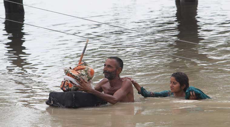 Pakistan villagers wade through floodwaters in Rajanpur Pakistan on Thursday