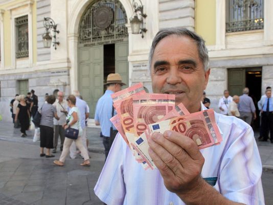 Pensioner Giorgos Petropoulos shows 10 euro notes in Athens