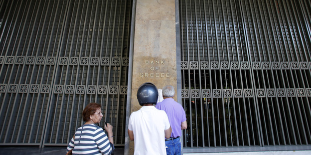 People read a sign outside the closed Bank of Greece in Athens