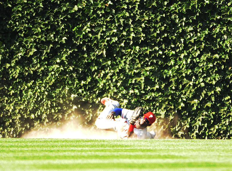 Phillies center fielder Odubel Herrera leans forward to make the final out after slipping on the warning track