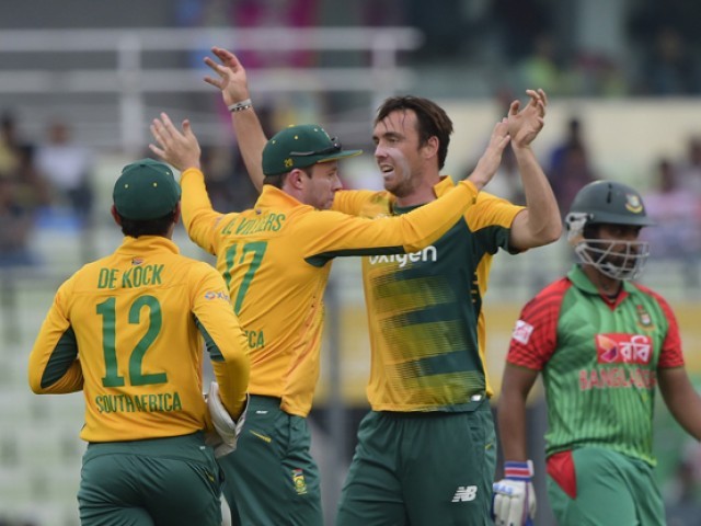 South African cricketer Kyle Abbott celebrates with teammate AB de Villiers after the dismissal of Bangladesh cricketer Tamim Iqbal during the first T20 cricket match between Bangladesh and South Africa at the Sher-e Bangla National Cricket Stadium