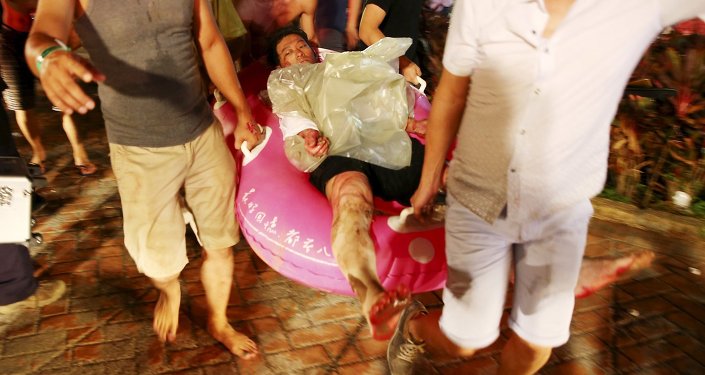 People carry an injured victim from an accidental explosion during a music concert at the Formosa Water Park in New Taipei City Taiwan