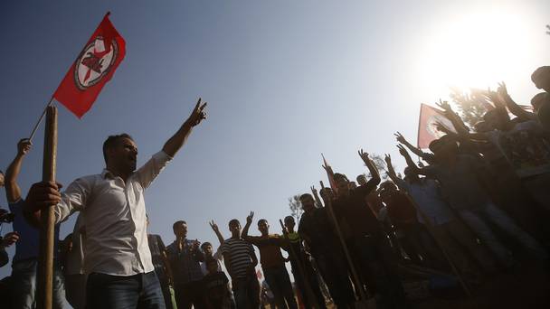 Relatives and friends of two of the victims of the Suruc explosion sing a national song during their funeral