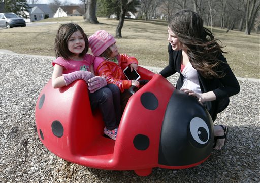 Michelle Halonen enjoying the warm day with daughters Madilyn left and Ellie at a park in St. Louis Park Minn. works full time at a gas station and still struggles to support her two young daughters. A new