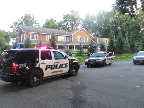 Greenburgh police cars outside 5 Payne Road where a retired police officer was shot twice while interrupting a break-in on Monday