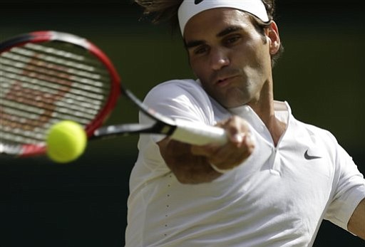 Roger Federer of Switzerland makes a return to Andy Murray of Britain during their men's singles semifinal match at the All England Lawn Tennis Championships in Wimbledon London Friday