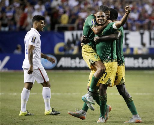 Jamaicas Rudolph Austin facing camera celebrates with teammates Joel McAnuff left and Je Vaughn Watson right as United States De Andre Yedlin walks off the pitch after Jamaica defeated the United States 2-1 in a CONCACAF Gold Cup soccer semifinal