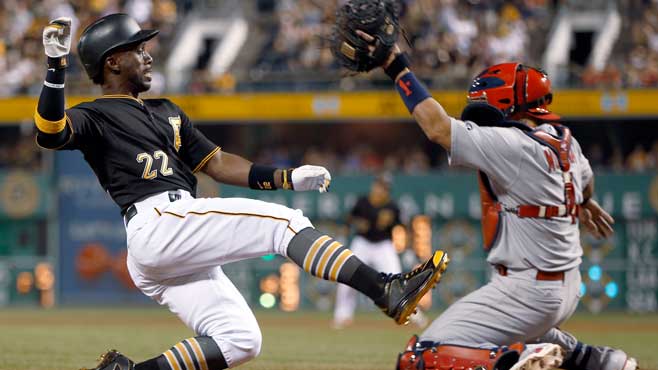 Pittsburgh Pirates&#039 Andrew Mc Cutchen scores from second base on a hit by Jung Ho Kang as the ball gets away from St. Louis Cardinals catcher Yadier Molina during the eighth inning of a baseball game Saturday