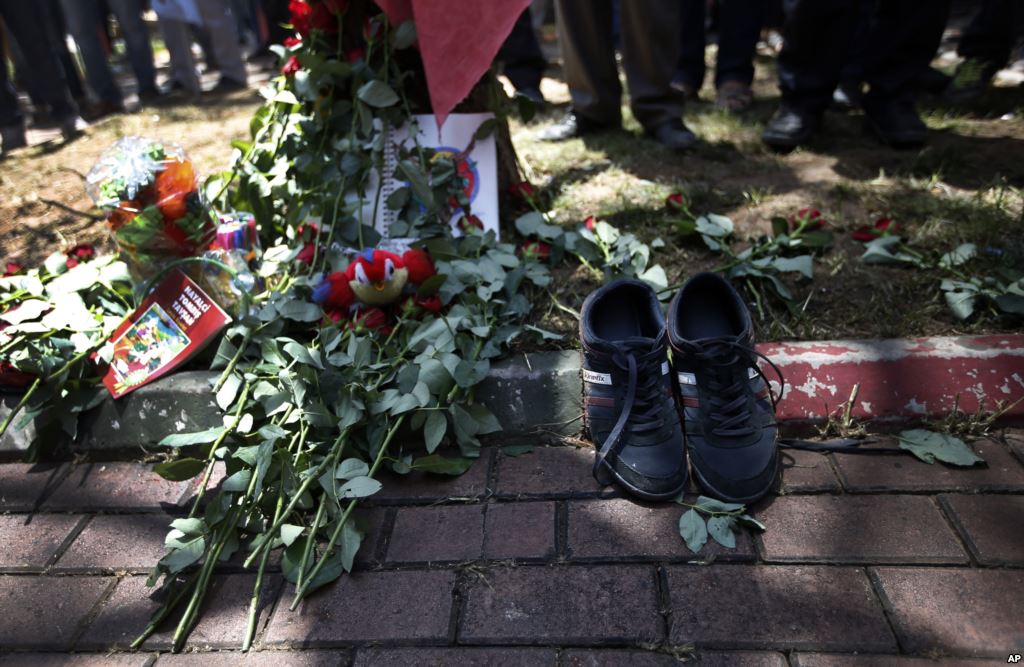 A pair of shoes belonging to a victim are seen next to flowers laid down by mourners at the site of Monday's explosion in the Turkish town of Suruc near the Syrian border Tuesday