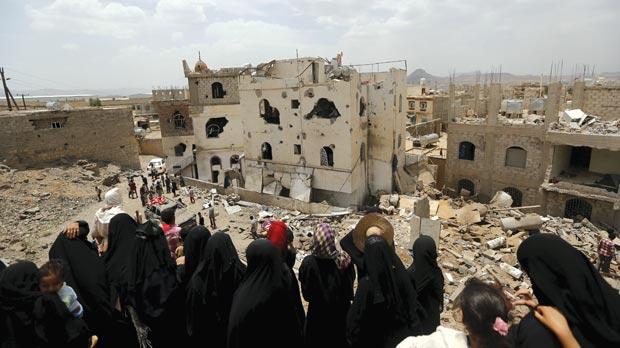 People look at the rubble remains of houses destroyed by a Saudi-led air strike in Yemen’s capital Sanaa