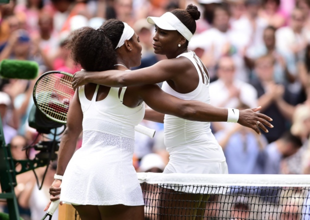 Serena Williams and Venus Williams embrace after their match during day Seven of the Wimbledon Championships at the All England Lawn Tennis and Croquet Club Wimbledon