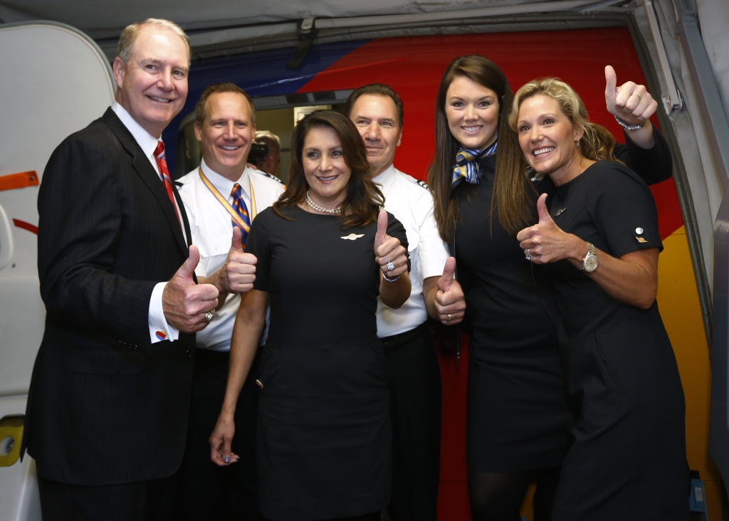 Flight attendants pilots join Southwest Airlines chairman and CEO Gary Kelly on the carrier's first nonstop flight beyond the Wright amendment boundaries in this Oct. 13