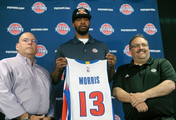 New Detroit Piston Marcus Morris holds his new jersey with Pistons president of basketball operations and head coach Stan Van Gundy right and general manager Jeff Bowe left during a news conference Friday