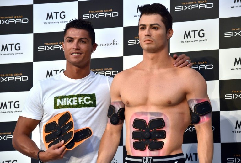 Portuguese football star Cristiano Ronaldo stands next to his look-alike figure made by a 3D printer during a promotional event in Tokyo