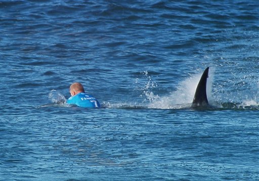 In this image made available by the World Surf League, Australian surfer Mick Flanning is pursued by a shark in Jeffrey's Bay South Africa Sunday