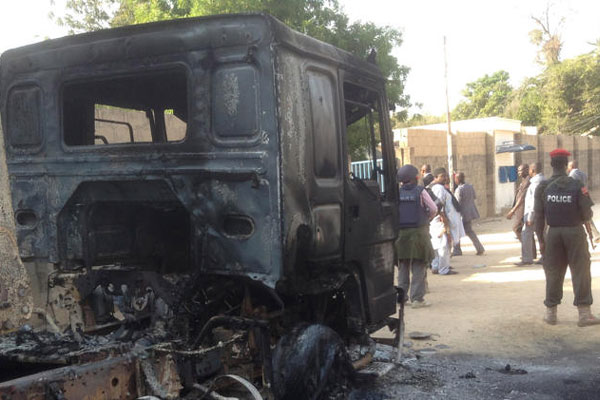 Policemen stand guards at a burnout truck following an attacked by Boko haram Islamists near an Air force base in Maiduguri Nigeria Monday Dec 2. 2013