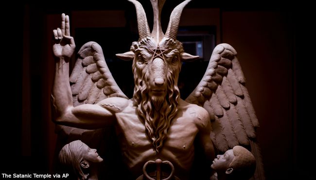 Satanic Temple shows a bronze Baphomet which depicts Satan as a goat-headed figure surrounded by two children