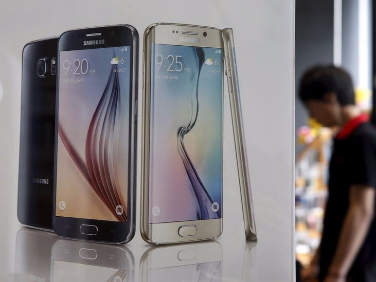 A man stands next to a banner promoting Samsung Electronics smartphone Galaxy 6 at a store in Seoul South Korea