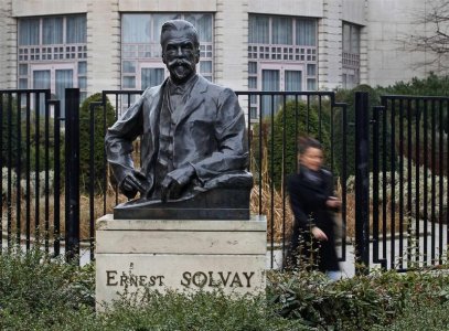 A woman walks past the statue of Ernest Solvay the founder of Belgian drug and chemicals maker Solvay outside the company's headquarters in Brussels