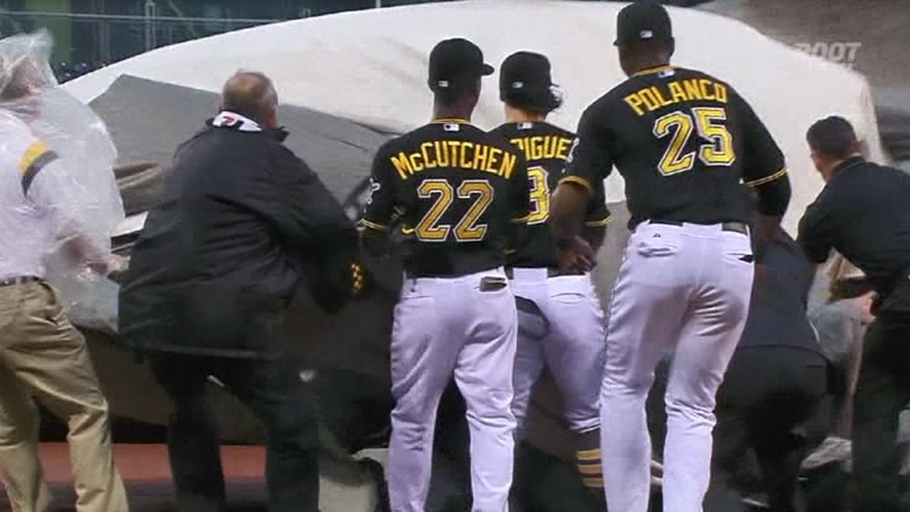 Three Pittsburgh Pirates help a grounds crew member trapped in a tarp Tuesday night