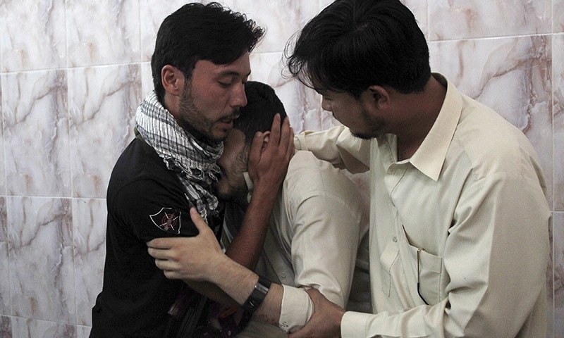 Men mourn the death of a relative who was killed with two others by unidentified gunmen on July 6. A policeman and two others were killed when unidentified assailants opened fire on them near the passport office at Joint Road in Quetta on Monday accordi