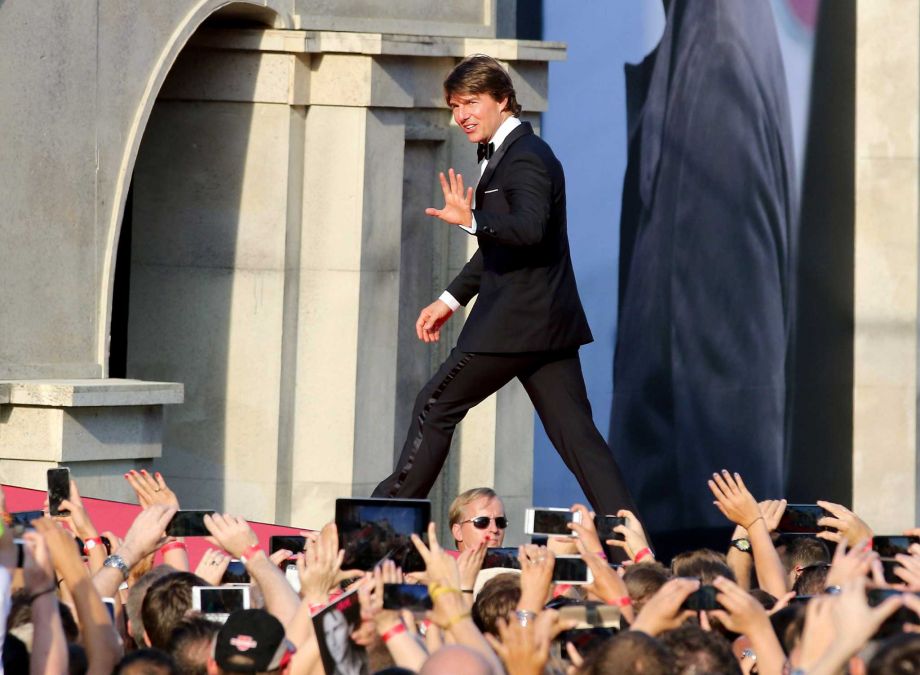 US actor Tom Cruise waves to fans as he attends the Mission Impossible – Rogue Nation World Premiere at the Vienna State Opera in Vienna Austria Thursday