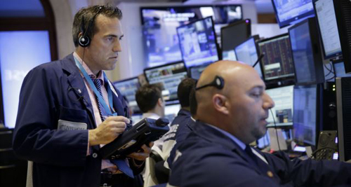 Traders work on the floor at the New York Stock Exchange in New York