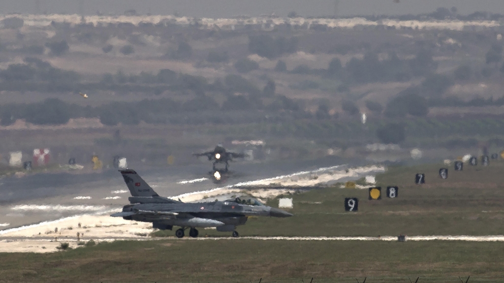 A U.S. Air Force plane takes off as a Turkish Air Force fighter jet taxis at the Incirlik airbase southern Turkey in 2013. Reversing an earlier policy Ankara has agreed to allow the U.S.-led coalition to fly anti-ISIS airstrikes from the base