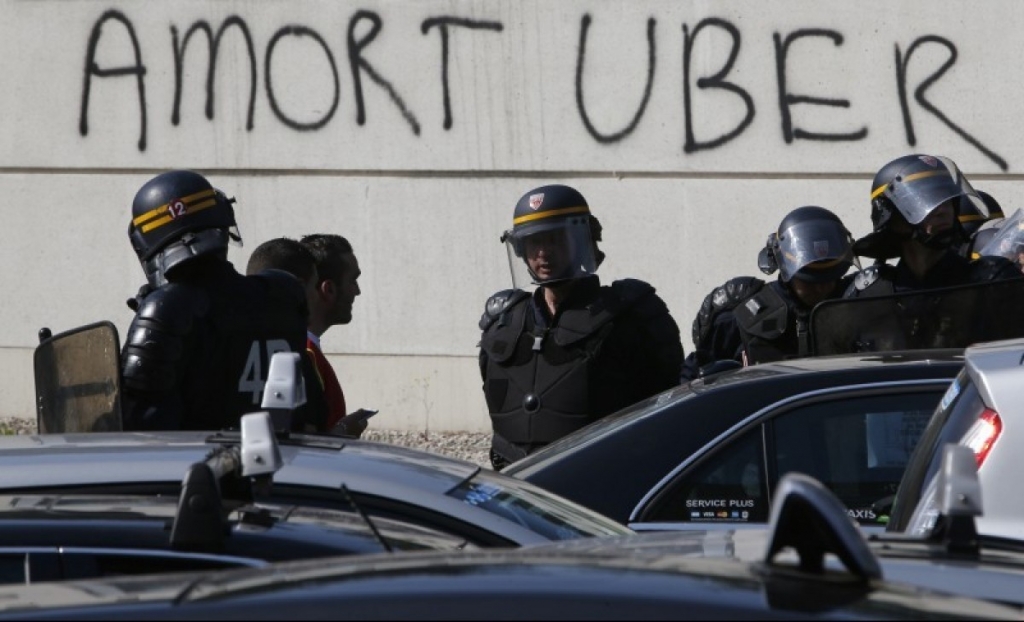 French riot police secure the Porte Maillot during a demonstration by French taxi drivers who are on strike to block the traffic on the Paris ring road during a national protest against car-sharing service Uber in Paris