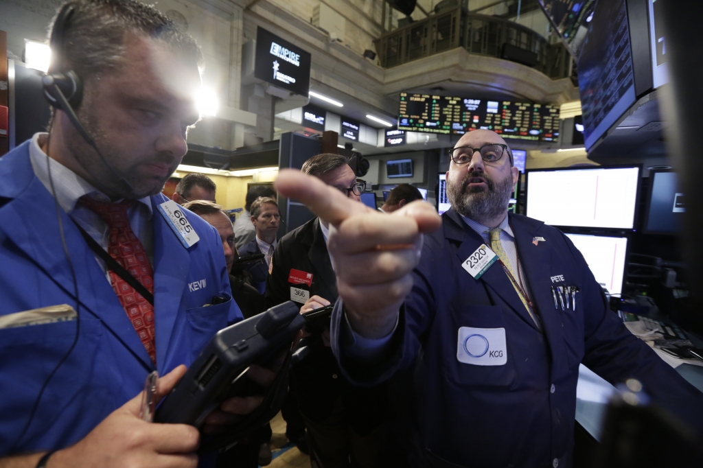 Specialist Peter Giacchi right works with traders at his post on the floor of the New York Stock Exchange Wednesday