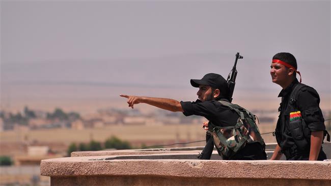 Fighters from the Kurdish People's Protection Units monitor the horizon during an operation in northeast Syria