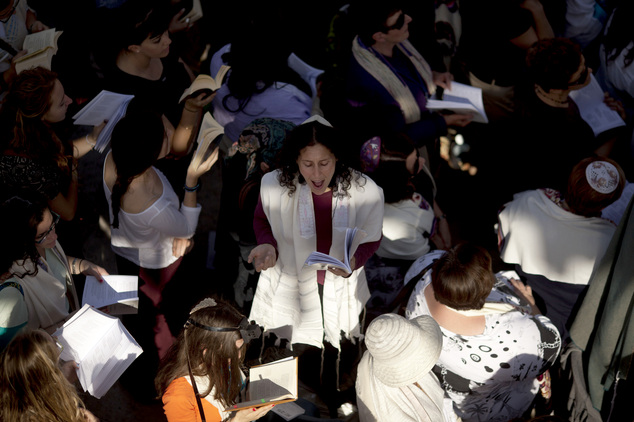 Jewish woman wears a prayer shawl as she prays at the Western Wall in Jerusalem's Old City. Israel's narr