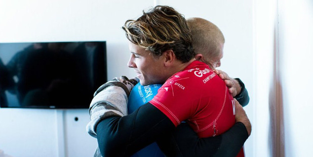 Loading Australian surfer Mick Fanning left hugs Australia's Julian Wilson after being attacked by a shark