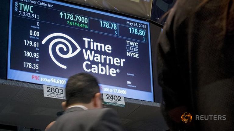 Traders work at the post where Time Warner Cable is traded on the floor of the New York Stock Exchange