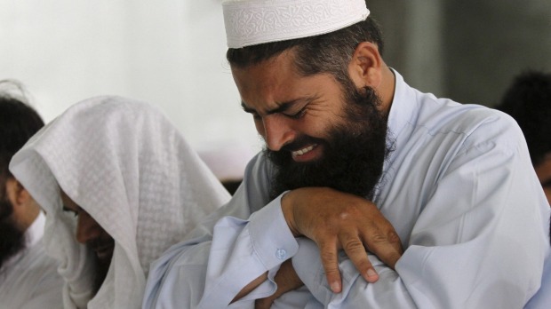 A man cries as he offers funeral prayers for the late Taliban leader Mullah Omar