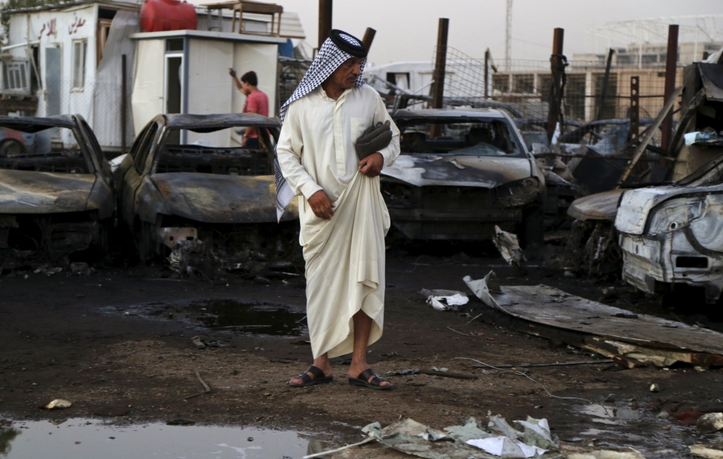 A man looks at the site of a car bomb attack at the mainly Shi'ite district of Habibiya in Baghdad