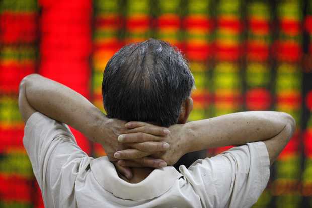 A man watches a screen board at a stocks market in Huaibei east China's Anhui Province