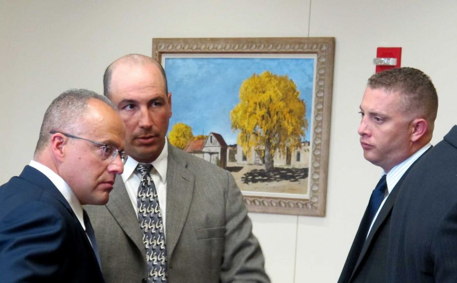 Defense attorney Luis Robles left talks to former Albuquerque detective Keith Sandy center and Albuquerque officer Dominique Perez right during a preliminary hearing in Albuquerque N.M. on Monday Aug. 17 2015. A judge is listening to testimony