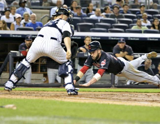 Indians&#39 Jason Kipnis slides past Yankees catcher Brian Mc Cann to score during the third inning Thursday